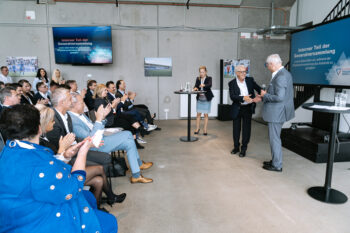 Zwei Männer schütteln sich die Hände auf der Bühne